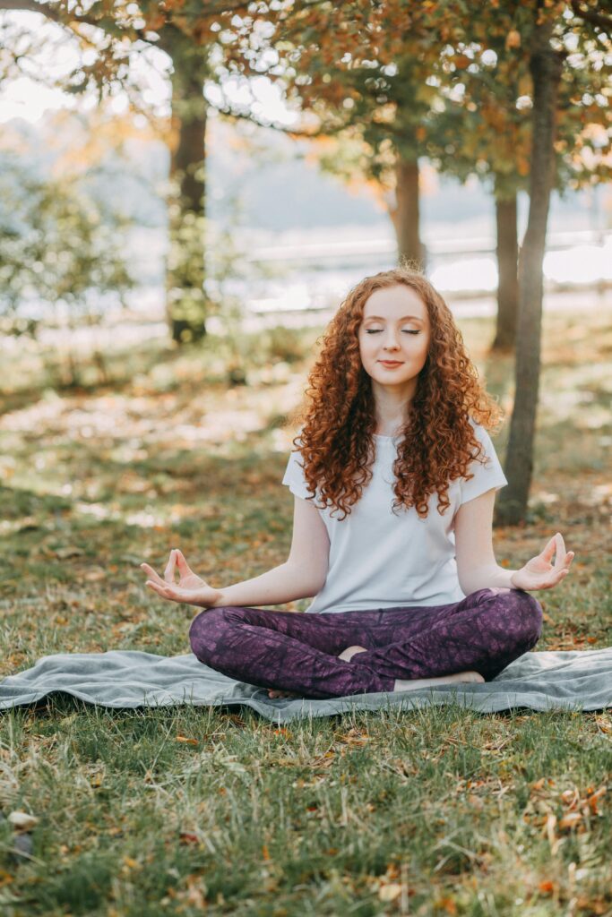 Woman meditating in a serene park for a healthy lifestyle