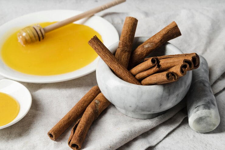 White plate featuring honey with cinnamon sticks – best natural remedies for acne at home, promoting healthier and clearer skin."